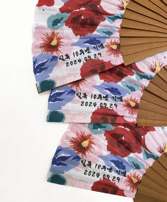 Diseño personalizado de abanico para la empresa "Ilboc" que utiliza dos flores típicas de cada país para simbolizar su unión